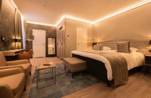 ein Hotelzimmer mit einem großen Bett und einem Sofa in der Unterkunft Hotel Acacia in Brügge