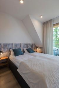 une chambre avec un grand lit blanc et une fenêtre dans l'établissement Apartamenty pod Giewontem SPA, à Zakopane