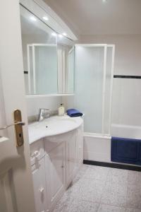 La salle de bains blanche est pourvue d'un lavabo et d'une douche. dans l'établissement Sea view luxury apartment, à Saint-Laurent-du-Var