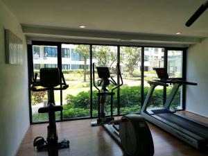un gimnasio con tres máquinas de correr y una gran ventana en 4 Floor - Centrio Condominium in Phuket town, en Phuket