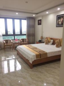 a bedroom with a large bed and a table and chairs at Royal Hotel in Hai Phong