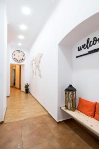 korytarz z kanapą i zegarem na ścianie w obiekcie Oasis by Cozyplace w Krakowie