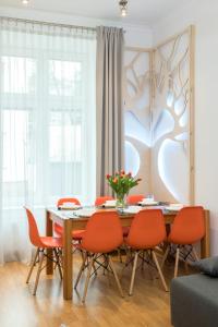 jadalnia ze stołem i pomarańczowymi krzesłami w obiekcie Oasis by Cozyplace w Krakowie