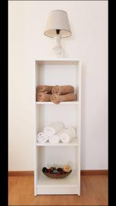uma prateleira branca com toalhas e um candeeiro em Charming House Lovro em Prožura