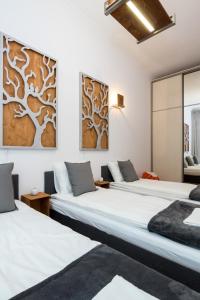 dwa łóżka w pokoju z obrazami na ścianie w obiekcie Oasis by Cozyplace w Krakowie