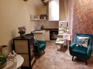 a living room with two chairs and a table and a kitchen at La Calleja in Arzúa +17 photos