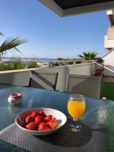 eine Schale Erdbeeren und ein Glas Orangensaft auf dem Tisch in der Unterkunft Camarate-golf sea views in Estepona