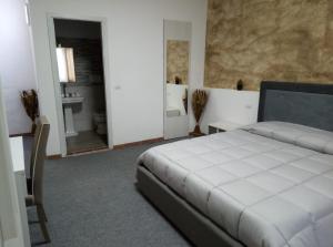 een slaapkamer met een wit bed en een badkamer bij Il Panorama in Sinalunga
