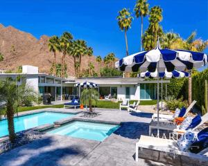 a house with a swimming pool and an umbrella at Villa Finola in Palm Springs