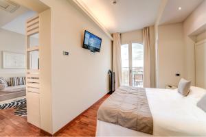 a bedroom with a bed and a tv on the wall at Terrazza Marconi Hotel&Spamarine in Senigallia