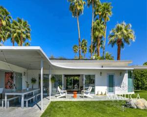 a white house with palm trees in the background at Villa Finola in Palm Springs