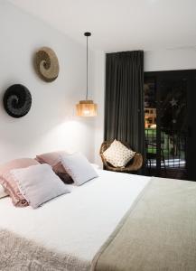 a bedroom with a large white bed and a window at Hostal Sa Malica in Blanes