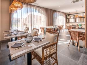 un restaurante con mesas y sillas de madera y una gran ventana en Hotel Gastronómico Torre de Galizano en Galizano