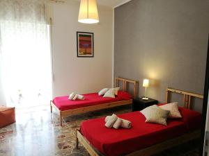 2 posti letto in una camera con lenzuola rosse di Appartamento Lorenzo Noto a Noto