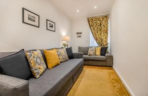 ein Wohnzimmer mit einem Sofa und 2 Sofas in der Unterkunft Lisbon Stay at Roma Boulevard in Lissabon