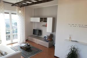 ein Wohnzimmer mit einem Sofa und einem TV in der Unterkunft Como Ricky Apartment in Cavallasca