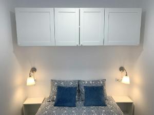 - une chambre avec un lit et 2 oreillers bleus dans l'établissement Apartamento 1ª Linea de Mar -WIFI- Aire Acondicionado, à Empuriabrava