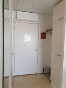 a white closet with a door in a room at Apartments N & P in Kotka