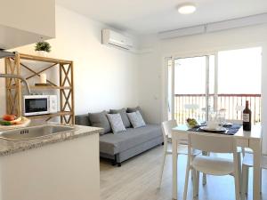 Il comprend une cuisine et un salon avec un canapé. dans l'établissement Apartamento 1ª Linea de Mar -WIFI- Aire Acondicionado, à Empuriabrava