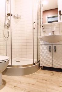 Un baño con ducha, inodoro y lavabo. en U House Apart-Hotel Poltava сучасні апартаменти в центрі, en Poltava