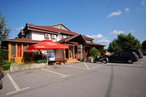 a store with a red umbrella in a parking lot at Plitvicka Vrela in Grabovac