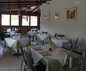 a dining room with green and white tables and chairs at Hotel Santo Stefano in Pieve Santo Stefano