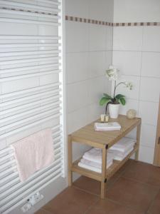 La salle de bains est pourvue d'une table, de serviettes et d'une douche. dans l'établissement Ferienwohnung Bolsterlang, à Bolsterlang