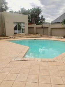 a large blue swimming pool in front of a house at Nine On Borghorst in Port Elizabeth