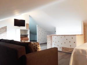 a living room with a couch and a television at Puerta Alameda Suites in Ronda