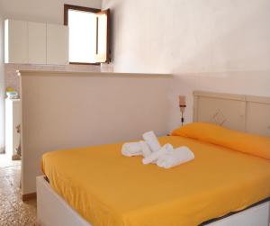 ein Schlafzimmer mit zwei Handtüchern auf einem gelben Bett in der Unterkunft Residence Lion in San Vito lo Capo