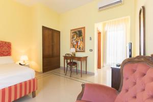 Masseria Sant'Anna في باري: غرفة نوم مع سرير ومكتب مع كرسي