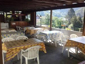 eine Gruppe von Tischen und Stühlen in einem Restaurant in der Unterkunft Chambres d'hôtes "La Truite" in Frinvillier