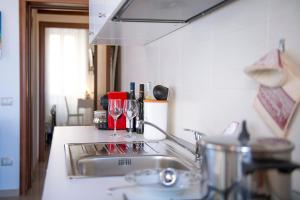 a kitchen sink with two wine glasses on the counter at Dimora Porto Canale in Monopoli