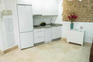 eine Küche mit weißen Schränken und einer Ziegelwand in der Unterkunft La Judería del Buen Viaje in Sevilla