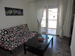 Apartment in Asprovalta في أسبروبالتا: غرفة معيشة مع أريكة وطاولة