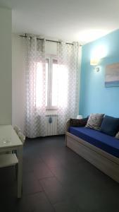 - un salon avec un lit et une fenêtre dans l'établissement DaNicolas Cairoli Apartment, à Monza