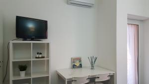 uma sala de estar com televisão numa prateleira branca em DaNicolas Cairoli Apartment em Monza