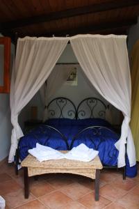 um quarto com uma cama azul com cortinas em Villa Mediterraneo em Castelluzzo
