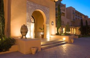哈馬馬特的住宿－阿罕布拉海水浴酒店，庭院中一座带拱门和楼梯的建筑