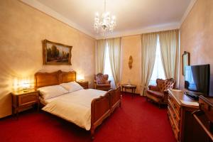 a bedroom with a bed and a flat screen tv at Hotel Na Zámečku in Ústí nad Orlicí