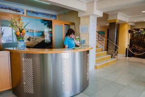 a woman standing at a counter in a lobby at Hotel las Dunas in Noja +71 photos