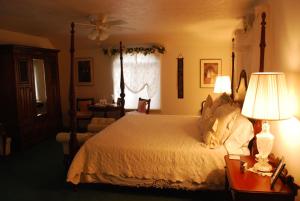 een slaapkamer met een bed en een tafel met een lamp bij Novel House Inn at Zion in Springdale