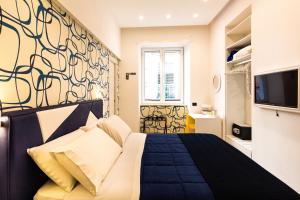 een slaapkamer met een bed en een tv aan de muur bij STARITA BED & PIZZA in Napels