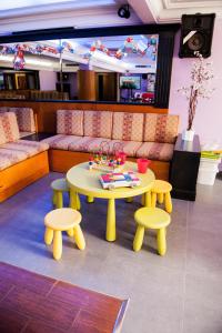 a yellow table and two stools and a table and chairs at Hotel las Dunas in Noja