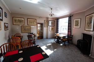 a dining room with a table and chairs and a fireplace at The Kirkmichael Hotel in Kirkmichael