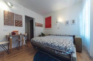 Schlafzimmer mit einem Bett, einem Tisch und einem Schreibtisch in der Unterkunft Accogliente monolocale alla Gran Madre in Turin