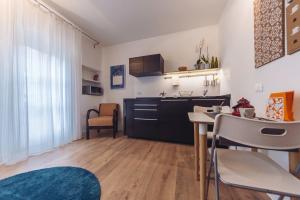kuchnia i salon ze stołem i krzesłami w obiekcie Accogliente monolocale alla Gran Madre w Turynie