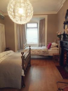 1 dormitorio con 2 camas y lámpara de araña en The Village Rooms en Dundalk