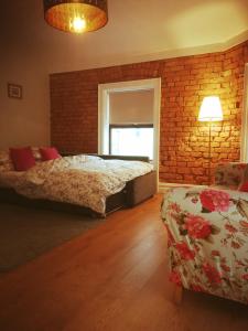 a bedroom with two beds and a brick wall at The Village Rooms in Dundalk