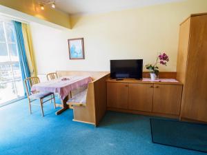 費爾茲姆斯的住宿－Aparthotel Alpina，一间房间,配有桌子和橱柜上的电视